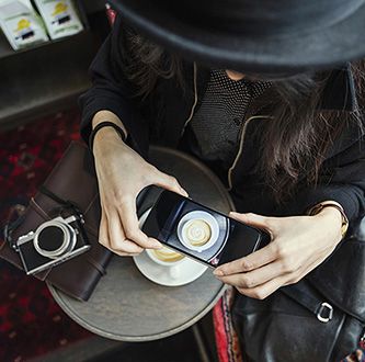 Femme photographiant une tasse de café.
