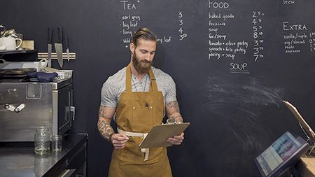 Homme planchette à pince dans un café.