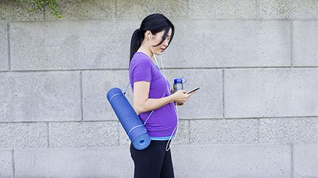 Jeune femme avec un tapis de yoga.