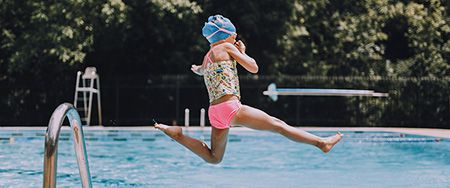 Fillette plongeant dans une piscine.