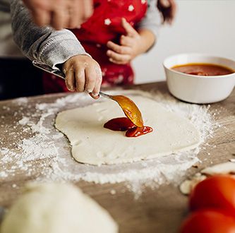 Fillette en train de preparer pizza.